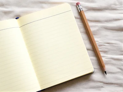 Open Notebook With Pencil On Textured Fabric