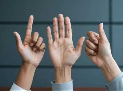 Three Hands Making Different Gestures Against Dark Background