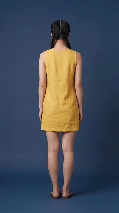 Woman Standing In Yellow Linen Dress Back View