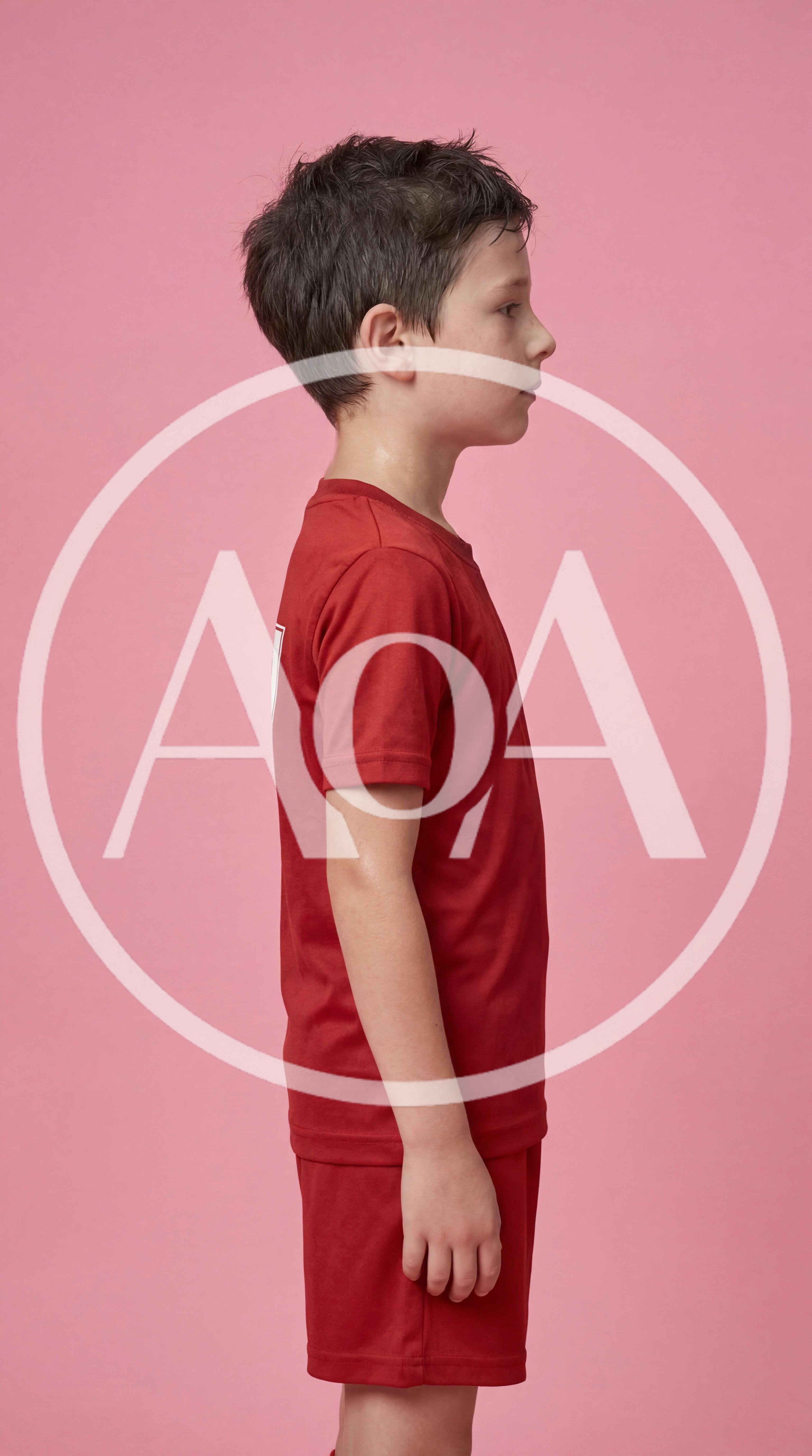 Young Boy Standing In Profile Wearing Red Sportswear