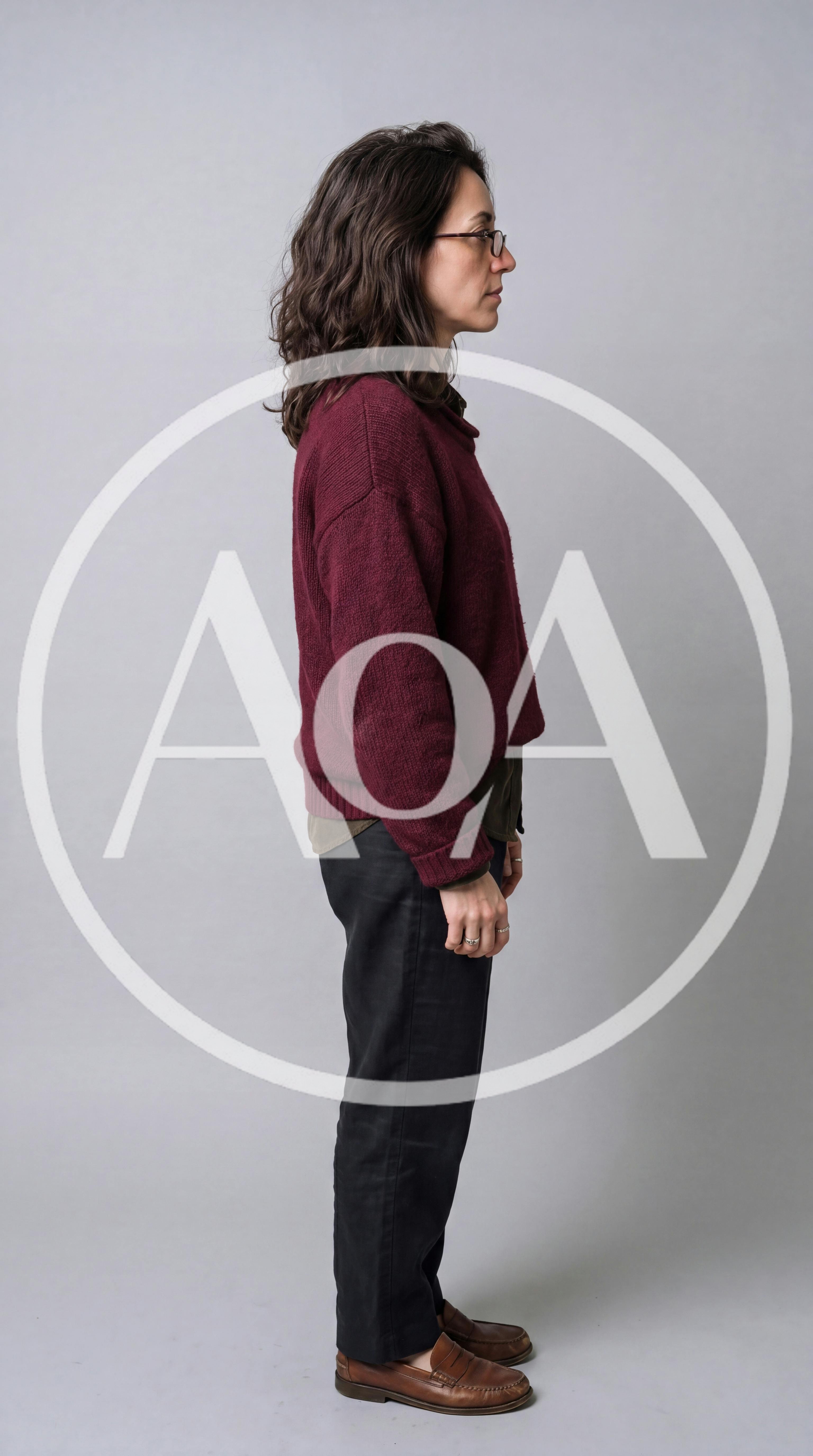 Side Profile Of A Woman Standing Against Grey Background