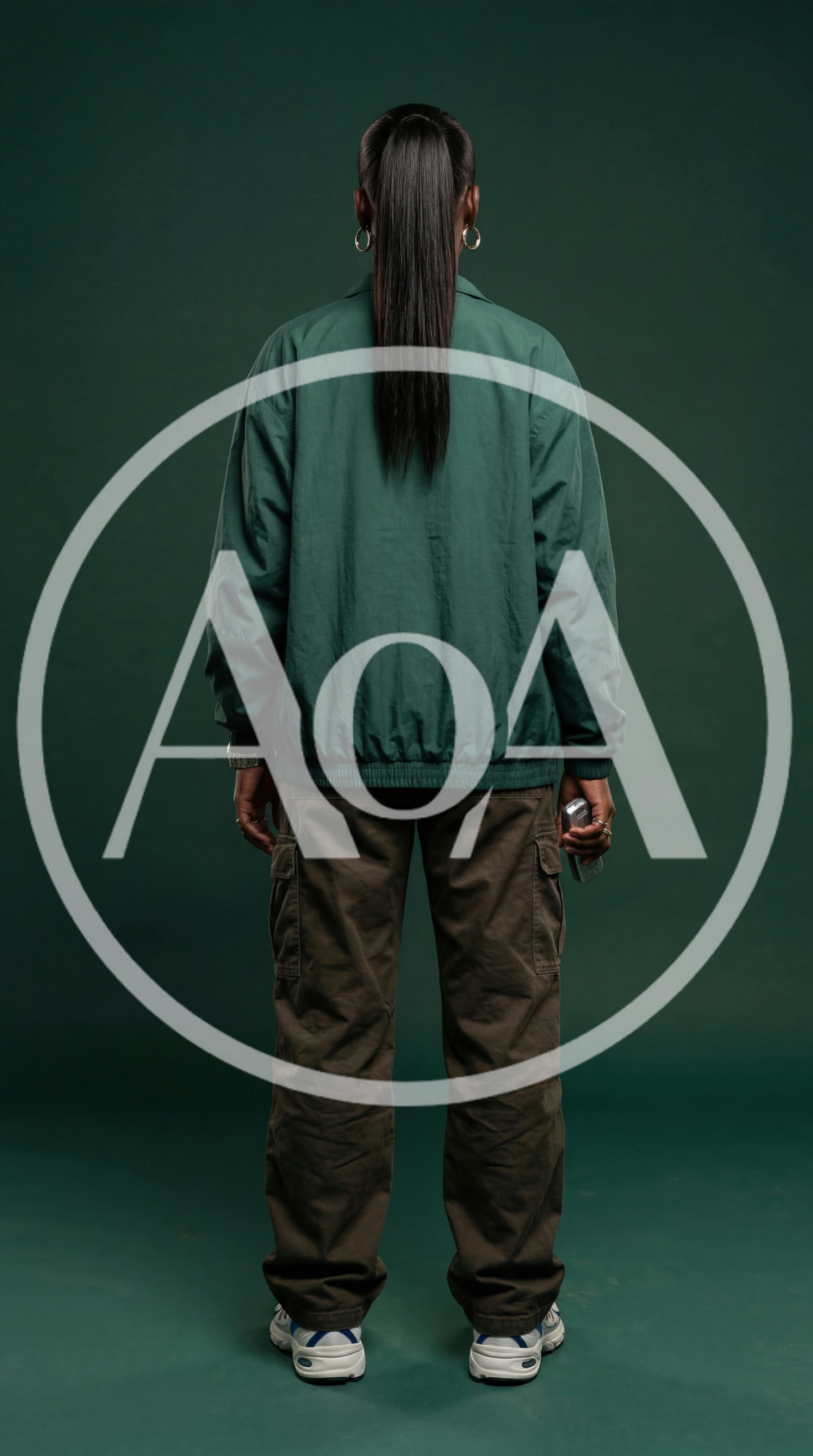 Person Standing Backwards In Green Jacket And Cargo Pants