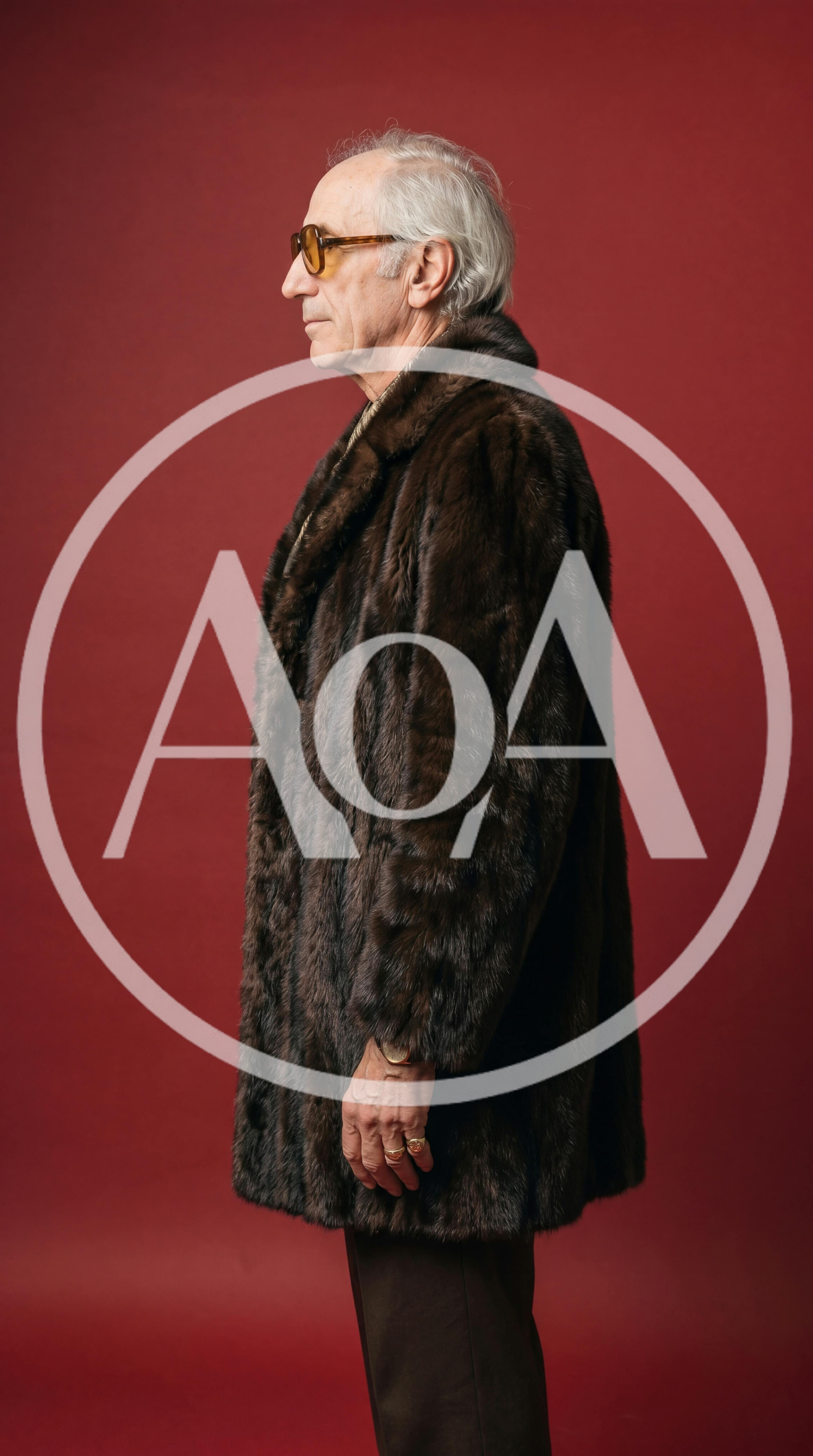 Senior Man Wearing Fur Coat Against Red Background
