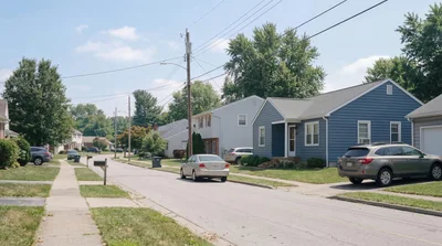 Suburban Residential Street With Houses And Parked Cars