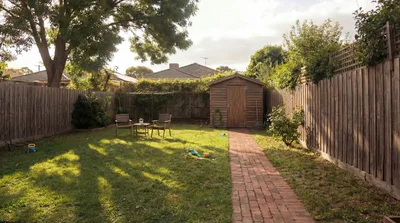 Backyard Garden With Wooden Shed And Brick Path