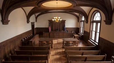 Empty Traditional Courtroom With Wooden Benches And Judge Bench