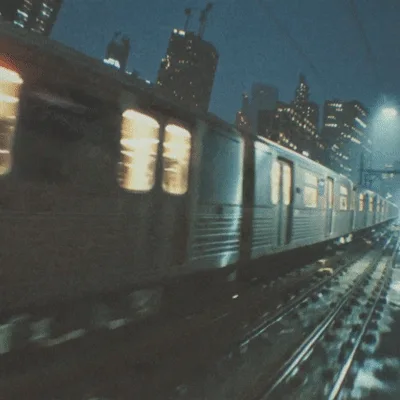 Subway Train Moving Through City At Night