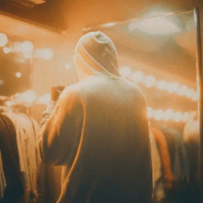 Person In Hoodie Flexing Muscles In Front Of Mirror