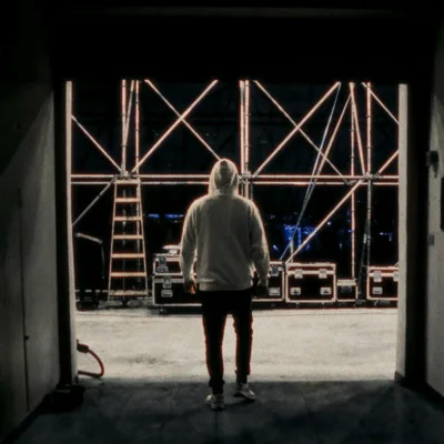 Person Walking Toward A Large Concert Stage Structure