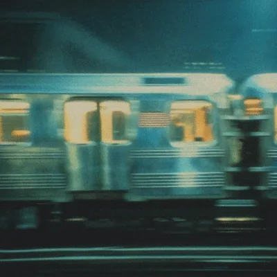 Commuter Train Moving Rapidly Through Night Cityscape