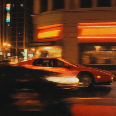 Red Ferrari Testarossa Driving Through City Streets At Night