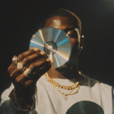 Man Holding Reflective Compact Discs In Dark Studio