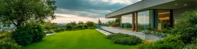 Modern Luxury House With Expansive Green Lawn At Sunset