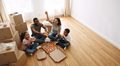 Happy Family Eating Pizza In New Home