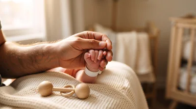 Father Holding Newborn Baby Hand in Nursery