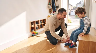 Father Helping Young Son Put On Sneakers