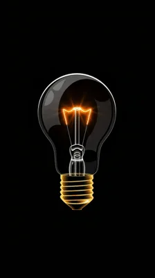 Glowing Light Bulb Turning On Against Black Background