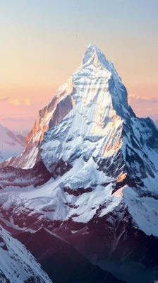 Aerial View Of Snow Covered Mountain Peak At Sunset