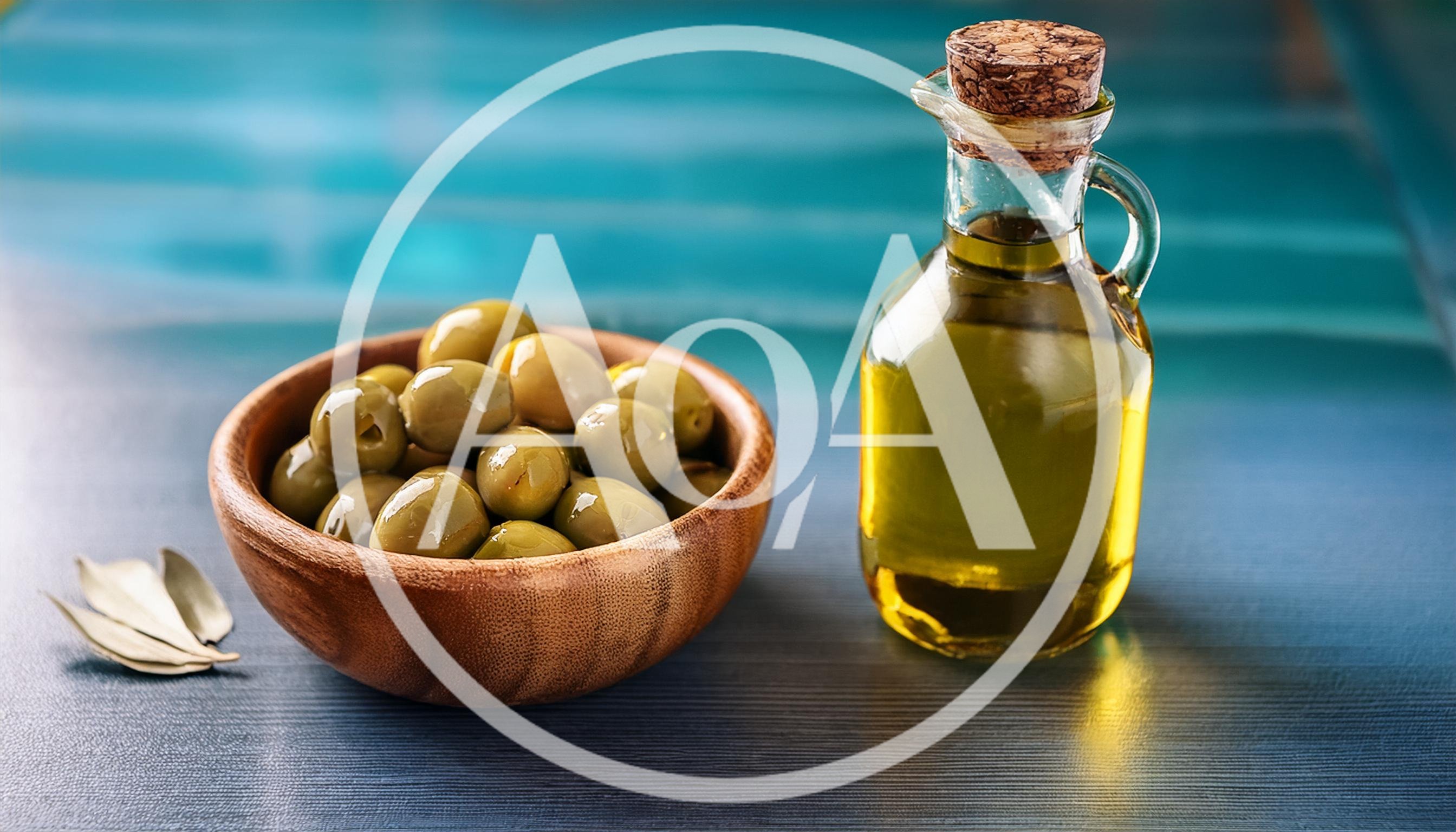 Green Olives In Wooden Bowl With Olive Oil Bottle