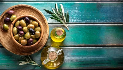 Wooden Bowl Of Olives And Olive Oil Bottles
