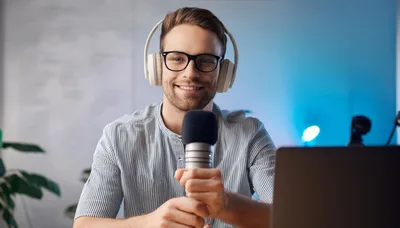 Young Man Recording Podcast With Microphone And Headphones