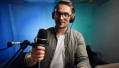 Podcaster Holding Microphone In Studio