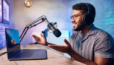 Young Man Recording Podcast In Home Studio