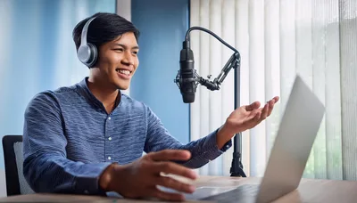Young Man Recording Podcast With Laptop And Microphone