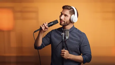 Young Man Singing Into A Microphone In A Studio