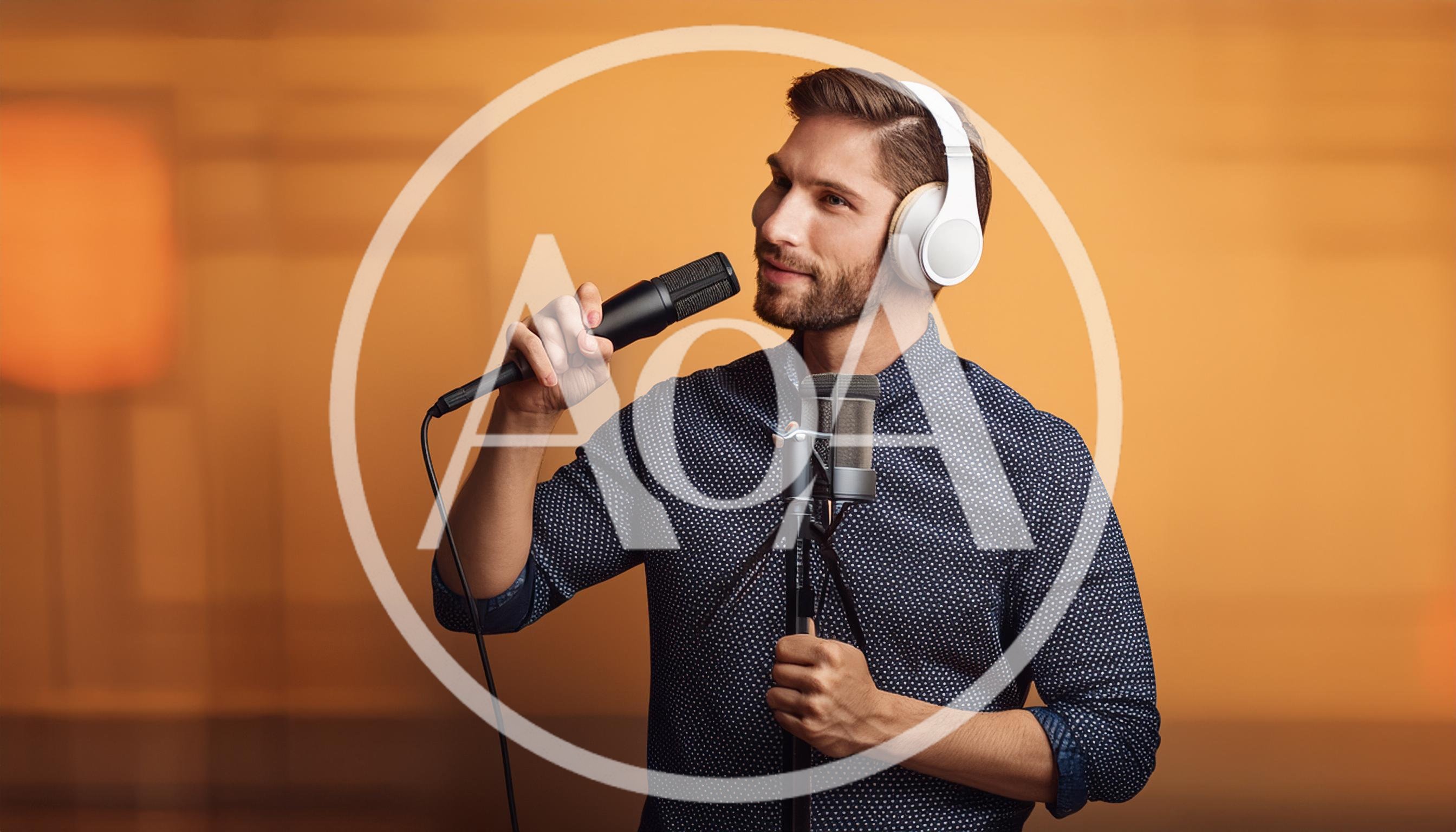 Young Man Singing Into A Microphone In A Studio