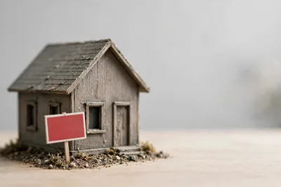Miniature Wooden House Model With Blank Real Estate Sign