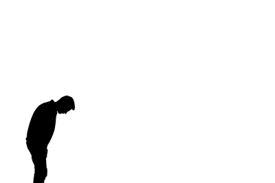 Silhouette Of A Man Bowing His Head In Sorrow