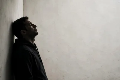 Depressed Man Leaning Against A Wall