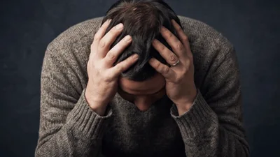 Stressed Man Holding Head In Hands