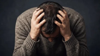 Stressed Man Holding Head in Hands