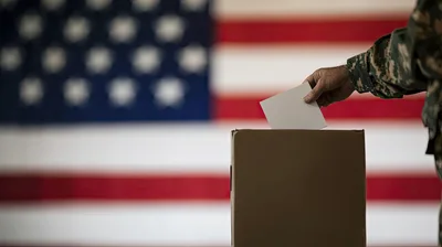 Military Personnel Casting A Vote In Ballot Box