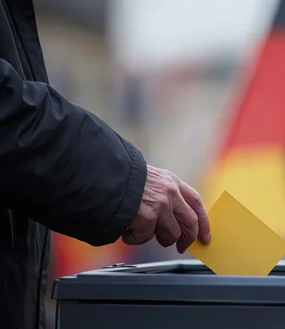 Elderly Person Casting A Vote In Ballot Box