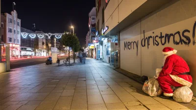 Santa Claus Sitting On Trash Bags At Night