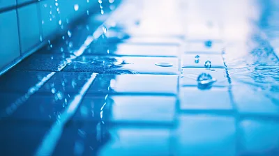 Water Droplets Falling Onto Blue Tiled Pool Surface