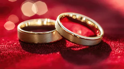 Two Gold Wedding Rings On Red Velvet Fabric