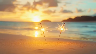 Two Burning Sparklers On A Tropical Beach At Sunset