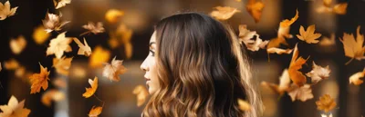 Profile Portrait of a Woman with Falling Autumn Leaves