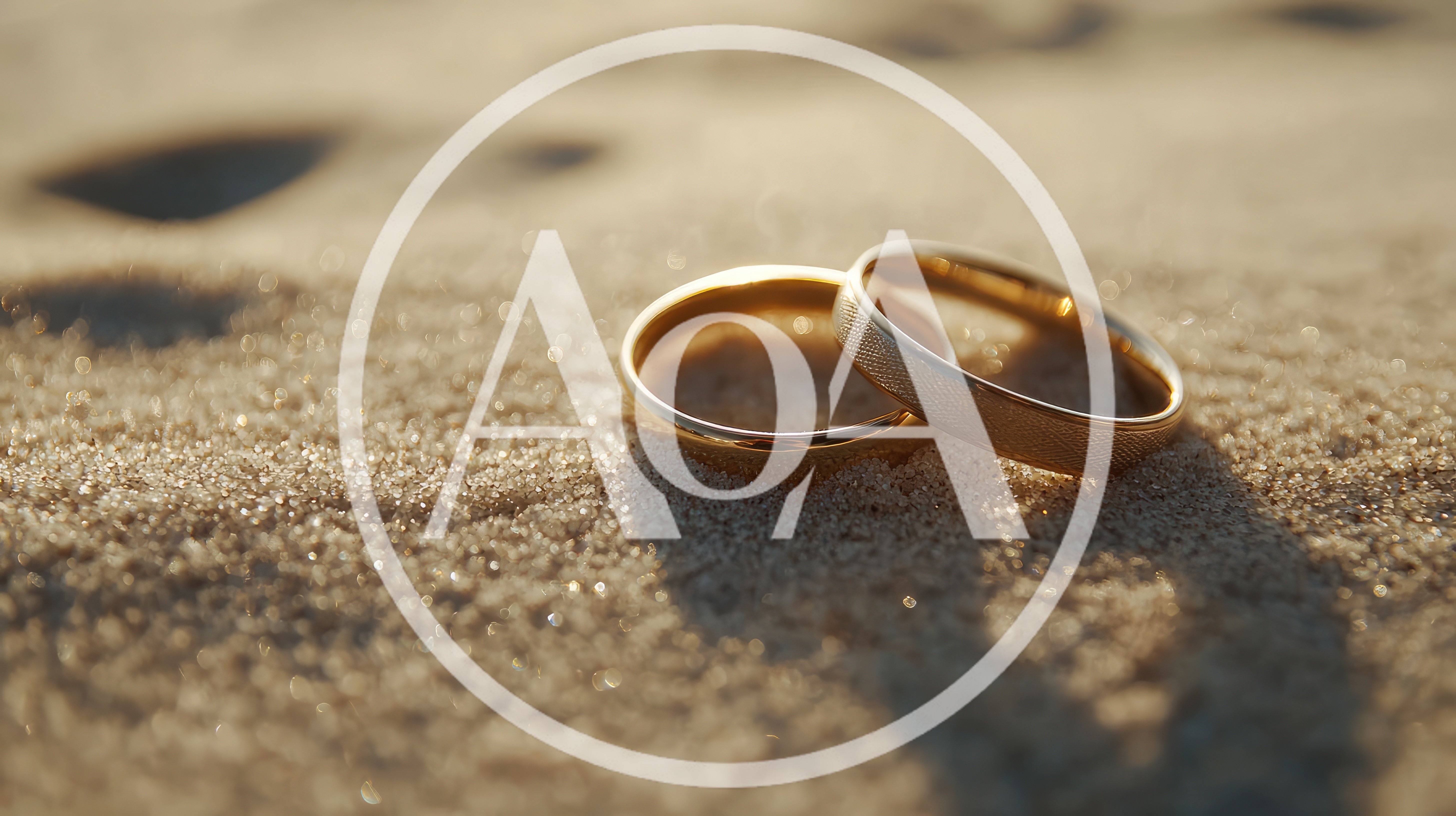 Two Gold Wedding Rings Resting On Sandy Beach