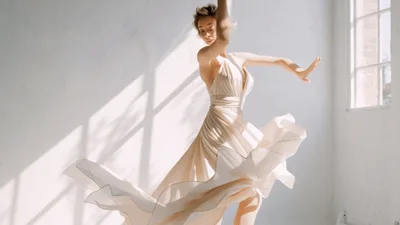 Elegant Woman Dancing In Flowing Beige Dress