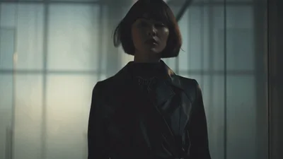 Stylish Woman Walking Through Modern Glass Office Corridor