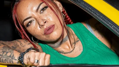 Tattooed Woman With Red Braids Looking Out Car Window
