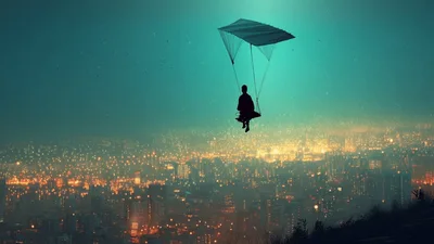 Person Paragliding Over A Glowing City At Night