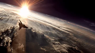 Fighter Jet Flying Above Clouds At High Altitude