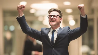 Excited Businessman Celebrating Success In Office Hallway