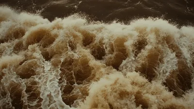 Turbulent Brown River Water Flowing Rapidly